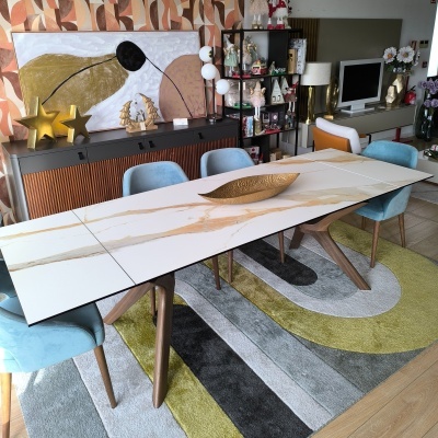 Mesa de jantar em pedra branca com veios dourados e cadeiras azuis