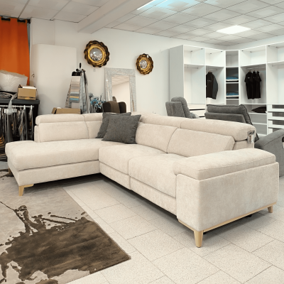 Sofá em L bege com almofadas cinza em loja com cadeiras, espelhos e prateleiras