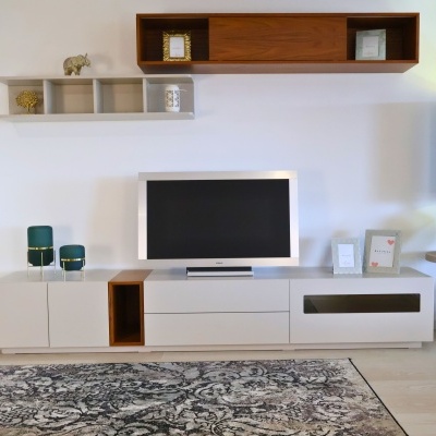 Móvel TV branco e madeira com decorações e tapete cinza