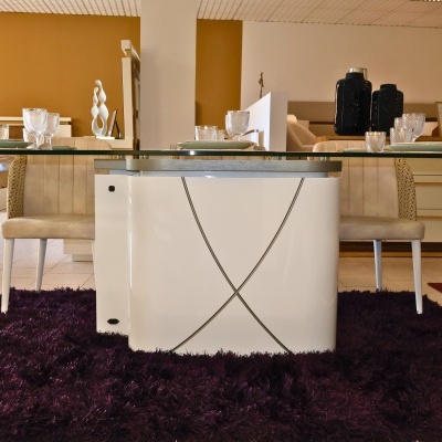 Mesa de jantar com tampo de vidro e base branca, cadeiras bege e tapete roxo