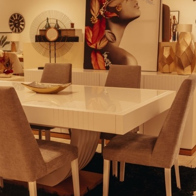 Mesa de jantar branca com cadeiras cinza e tapete preto num interior decorado