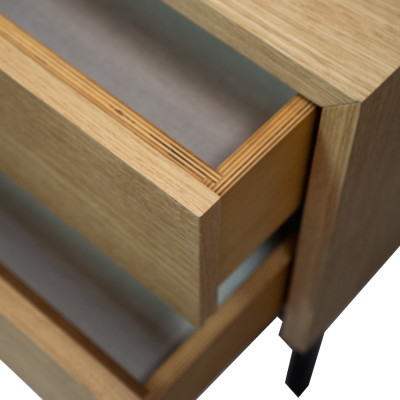 Móvel de madeira clara com gavetas abertas e pés pretos