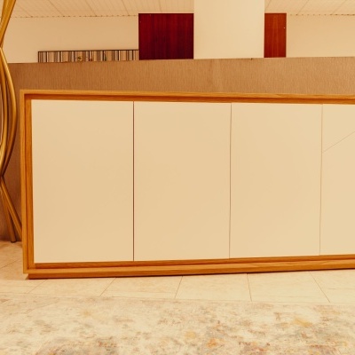 Aparador de madeira clara com portas brancas em ambiente interior