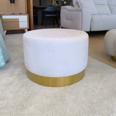 Pufe redondo branco com base dourada em sala com sofá e mesa de apoio
