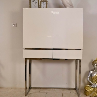 Móvel branco moderno com estrutura metálica e estátua de Buda dourada ao lado