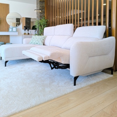 Sofá branco reclinável com chaise longue e almofadas numa sala moderna