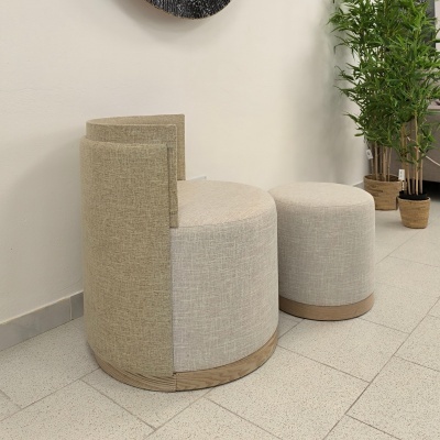 Dois pufes redondos bege com base de madeira ao lado de planta em vaso