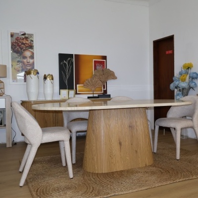 Sala de jantar com mesa oval clara e cadeiras estofadas bege