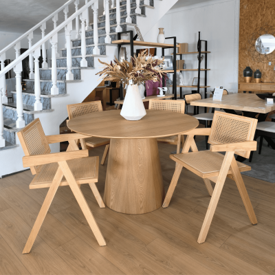 Mesa de jantar redonda em madeira clara com quatro cadeiras em palhinha