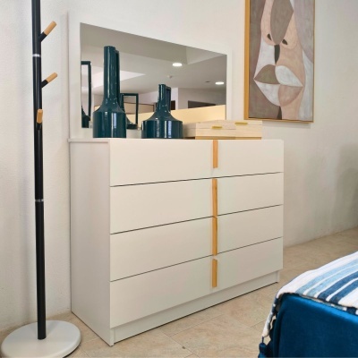 Cômoda branca com espelho e objetos decorativos em ambiente interior