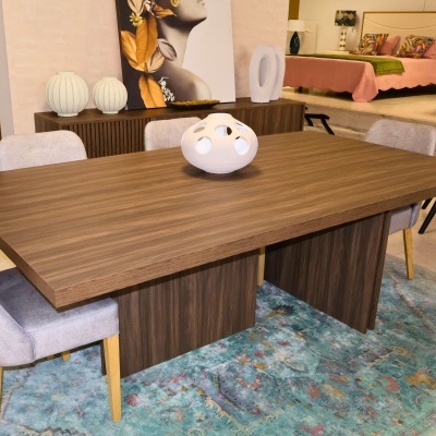 Mesa de madeira castanha com cadeiras cinzentas e tapete azul e verde