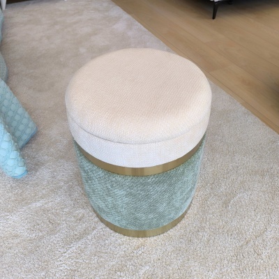Pufe redondo branco e verde com detalhes dourados sobre tapete claro