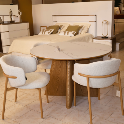 Mesa de jantar redonda com tampo branco e cadeiras estofadas em loja de móveis