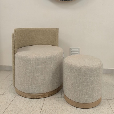 Conjunto de cadeira estofada e pufe redondo em tecido bege com base de madeira clara