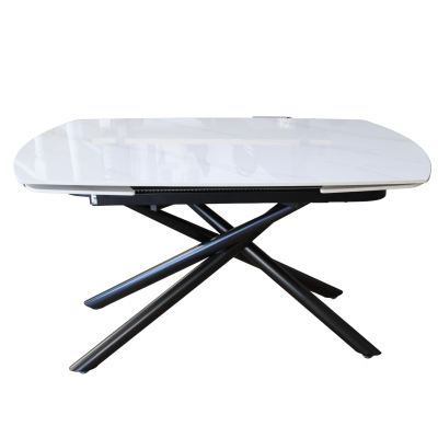 Mesa moderna com tampo branco brilhante e base de metal preta com pernas cruzadas.