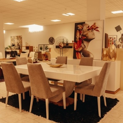 Mesa de jantar branca com seis cadeiras cinzas e tapete preto