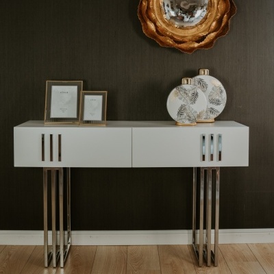 Aparador branco com pernas metálicas e decoração com molduras e jarros redondos