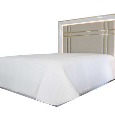 Cama de casal branca com cabeceira com detalhes dourados e colcha branca texturizada