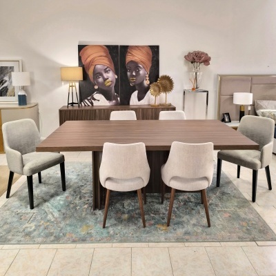 mesa de jantar de madeira com seis cadeiras cinzentas num tapete com decoração abstrata