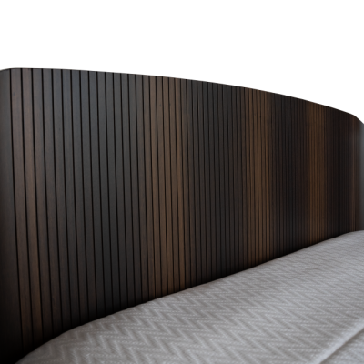 Cabeceira de cama em madeira escura com ranhuras verticais e colchão branco texturizado