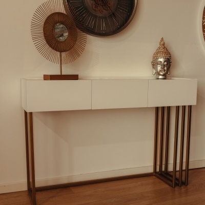 Aparador branco com pés dourados, escultura cabeça de Buda, espelho redondo dourado e relógio de parede com numerais romanos