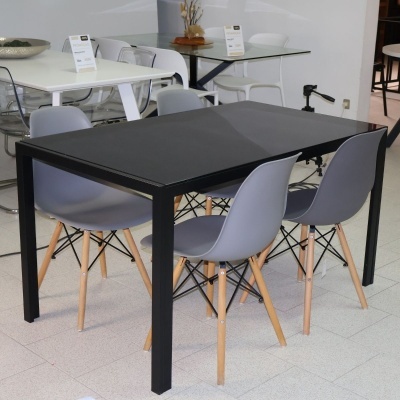 Mesa quadrada preta com quatro cadeiras cinzentas e pernas de madeira