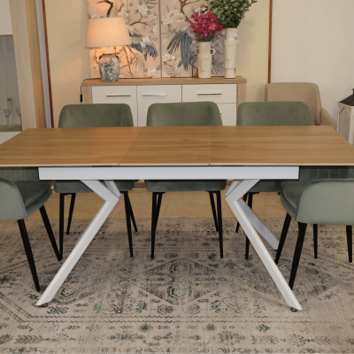 Mesa de jantar de madeira clara com pernas brancas em Z e cadeiras verdes sobre tapete cinza
