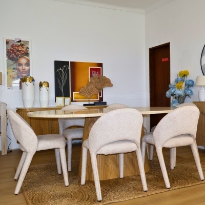 Conjunto de sala de jantar com mesa oval em madeira clara e cadeiras estofadas bege