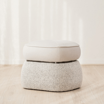 Pufe quadrado com almofadas bege e cinza sobre chão de madeira clara