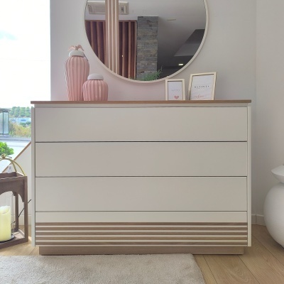 Cómoda branca com detalhes em madeira e decoração com jarros e molduras