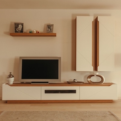 Móvel de sala de estar com base branca e madeira, dois armários suspensos brancos, prateleira com quadros e figuras, televisão e tapete claro sobre chão de madeira
