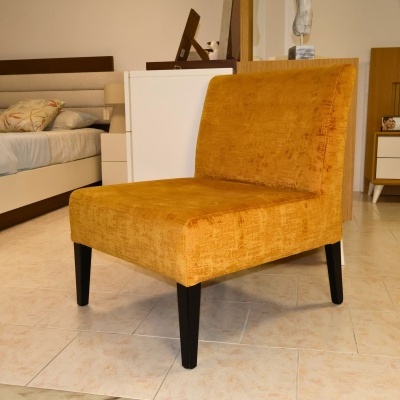 Poltrona amarela ocre com pernas pretas num quarto contemporâneo
