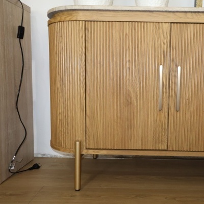 aparador em madeira clara com pés e puxadores dourados