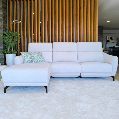 Sofá cinza claro com chaise longue, almofadas decorativas, em sala com parede de madeira