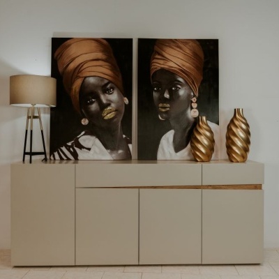 Móvel aparador creme com decoração e pinturas de retratos femininos em parede branca