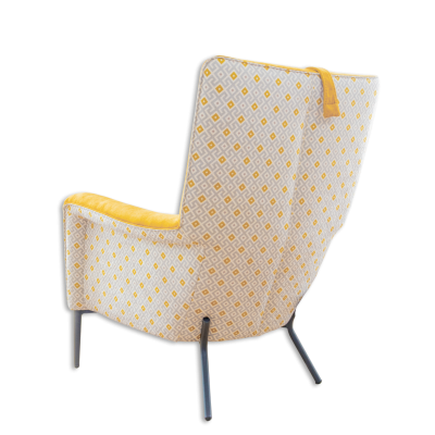 Poltrona com padrão geométrico branco e amarelo e pernas metálicas pretas.