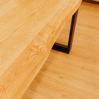 Mesa de madeira clara com pernas pretas em piso de madeira clara