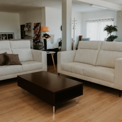 Conjunto de sofás brancos, mesa de centro escura e sala moderna