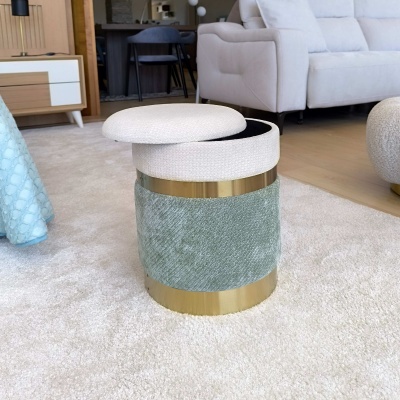 Pufe redondo verde e creme com base dourada numa sala de estar