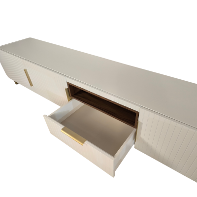 Móvel de TV branco com gaveta aberta e puxadores dourados