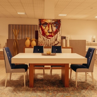 Mesa branca com pernas de madeira e quatro cadeiras azuis em sala decorada com pintura de rosto feminino.