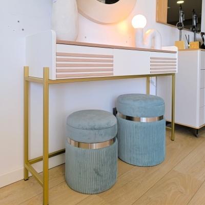 Mesa de apoio branca com detalhes em madeira e dourado com dois pufes azuis aveludados