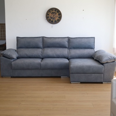 Sofá chaise longue cinzento em sala com chão de madeira e relógio de parede