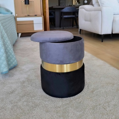 Pufe redondo cinza e preto com faixa dourada em ambiente de sala