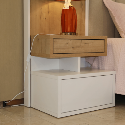 Mesa de cabeceira branca e madeira com candeeiro vermelho ao lado de cama rosa