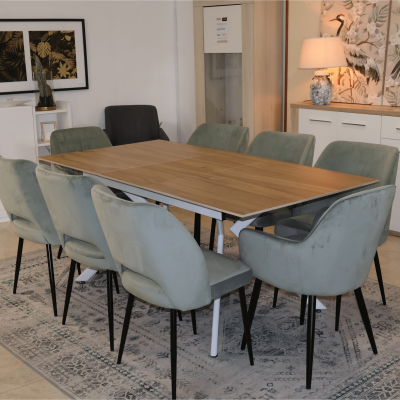 Conjunto de mesa de jantar retangular em madeira clara com oito cadeiras estofadas cinza esverdeado, em sala moderna com tapete e decoração