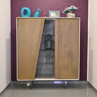 Móvel de madeira com vidro central, copos, jarro e decoração com vasos e flores artificiais