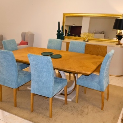 Mesa de jantar de madeira com seis cadeiras azuis em ambiente interior