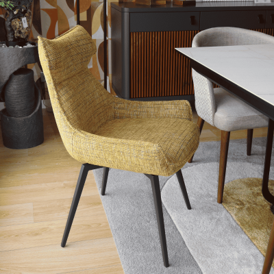 Cadeira de sala de jantar amarela com pernas pretas ao lado de mesa e carpete cinza