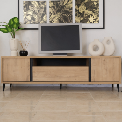 Móvel de TV de madeira com monitor, vasos decorativos e quadros dourados de folhas na parede